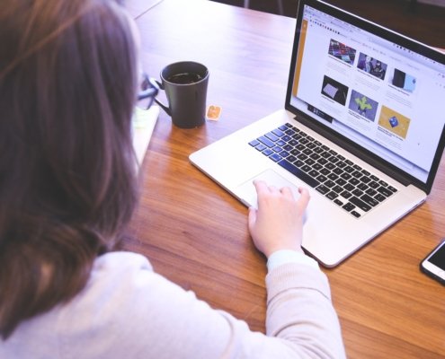 Großaufnahme, Dame, die an einem Laptop sitzt und mit der rechten Hand das Mousepad bedient
