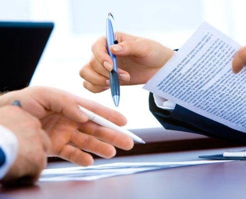 Großaufnahme, Frau hält Stift und Dokument in der Hand