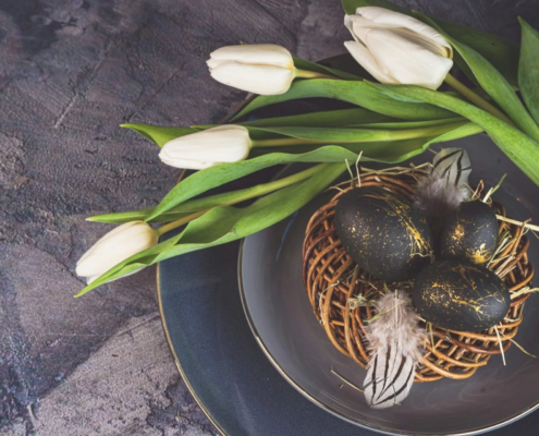 Osternest mit schwarzgoldenen Eiern und weißen Tulpen Osternest mit schwarz-goldenen Eiern und weißen Tulpen
